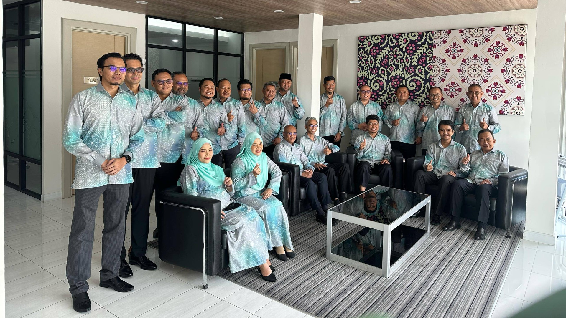 A client team wearing soft green TIYZI.CO batik uniforms